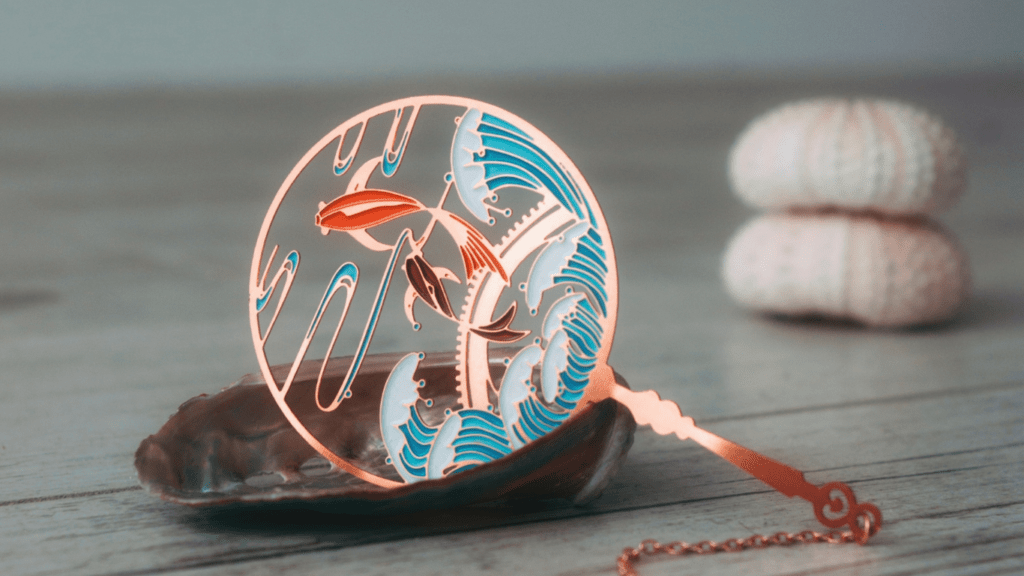 a necklace with a shark on it sitting on top of a wooden table