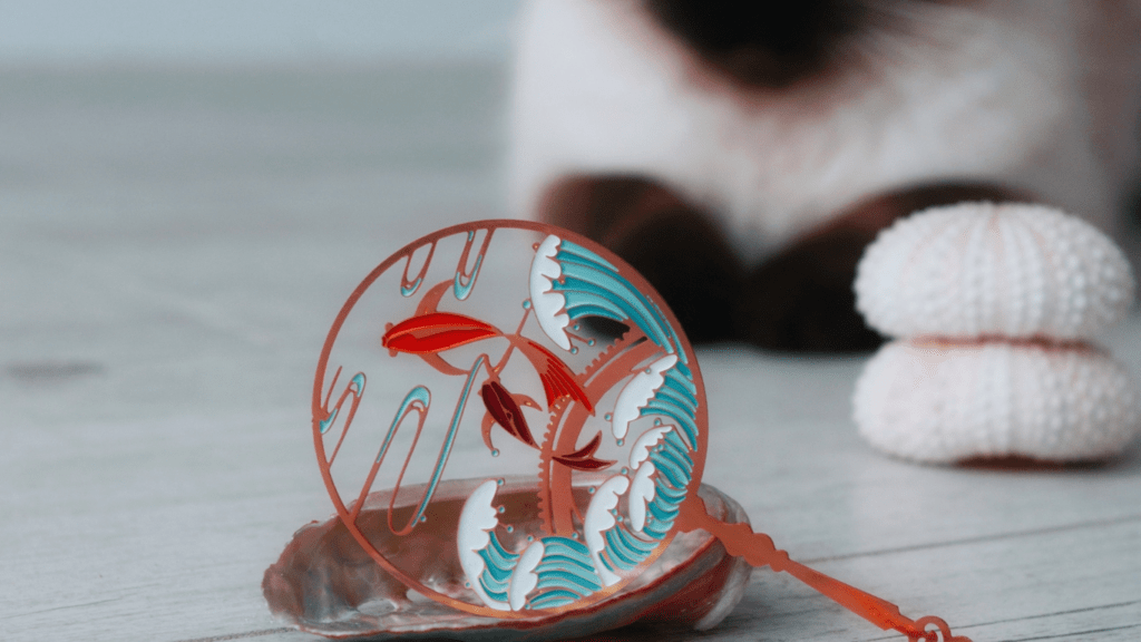 a necklace with a shark on it sitting on top of a wooden table